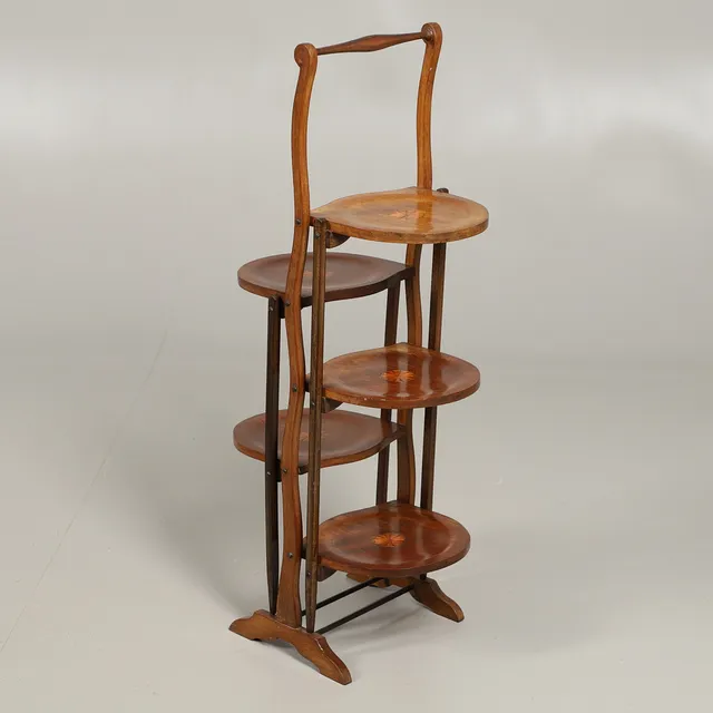 AN EDWARDIAN INLAID MAHOGANY FIVE TIERED FOLDING CAKE STAND.