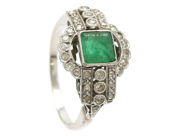 RING, 18K vitguld, smaragd, 6 åttkantslipade diamanter samt mindre rosenslipade diamanter ca 0,20 ctv, stl 17,5 mm, vikt 4,5 g, smaragd med nagg, ett fåtal diamanter med nagg och skador.