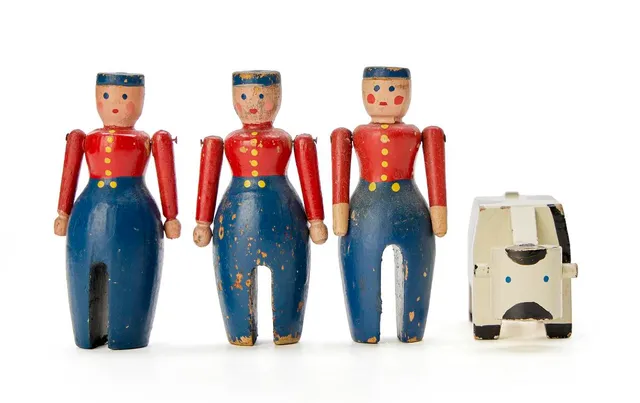 A collection of lacquered wood toys, comprising three men and a cow. Made by Kay Bojesen. Unmarked. Men: H. 8 cm. Cow: H. 4 cm. L. 9 cm. (4)