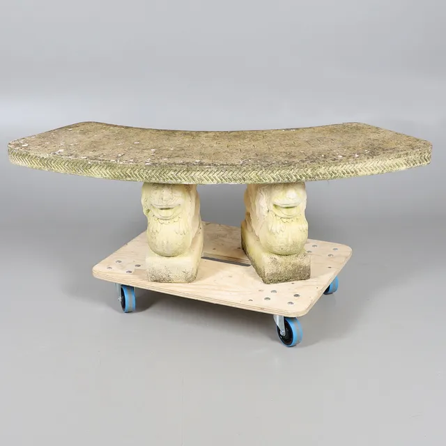 A CONCRETE GARDEN BENCH.