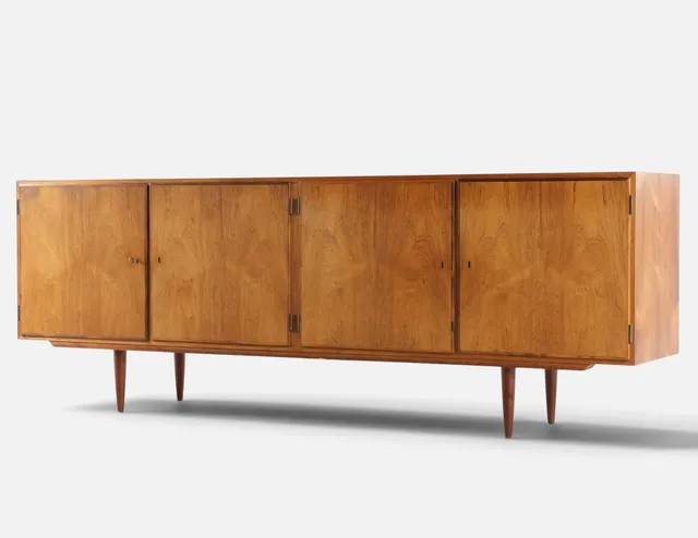 CARLO JENSEN. Lav dobbeltskænk af palisander, front med fire låger, bag hvilke hylder og udtræksbakker. Udført hos Hundevad & Co. Danmark, 1960'erne.