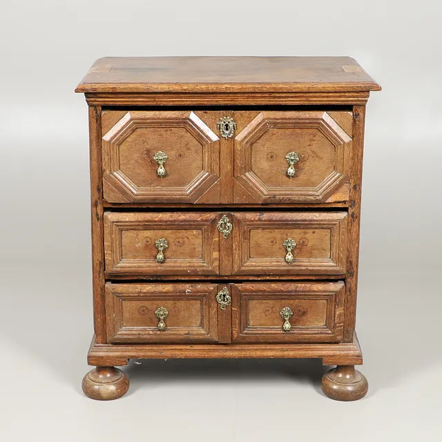 A 17TH CENTURY STYLE OAK DWARF CHEST OF DRAWERS.