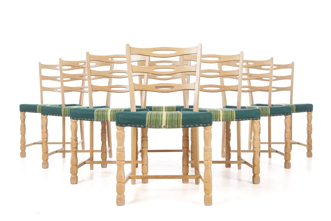 Danish furniture manufacturer. Set of eight chairs made of solid oak, upholstered in greenish striped fabric, Kjærnulf style (8) — Furniture/Chairs — Lauritz