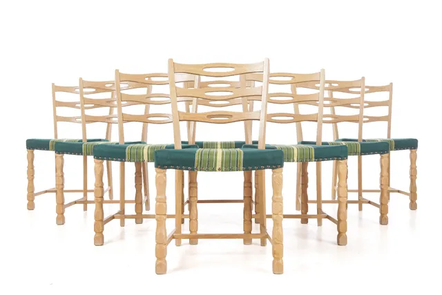 Danish furniture manufacturer. Set of eight chairs made of solid oak, upholstered in greenish striped fabric, Kjærnulf style (8)