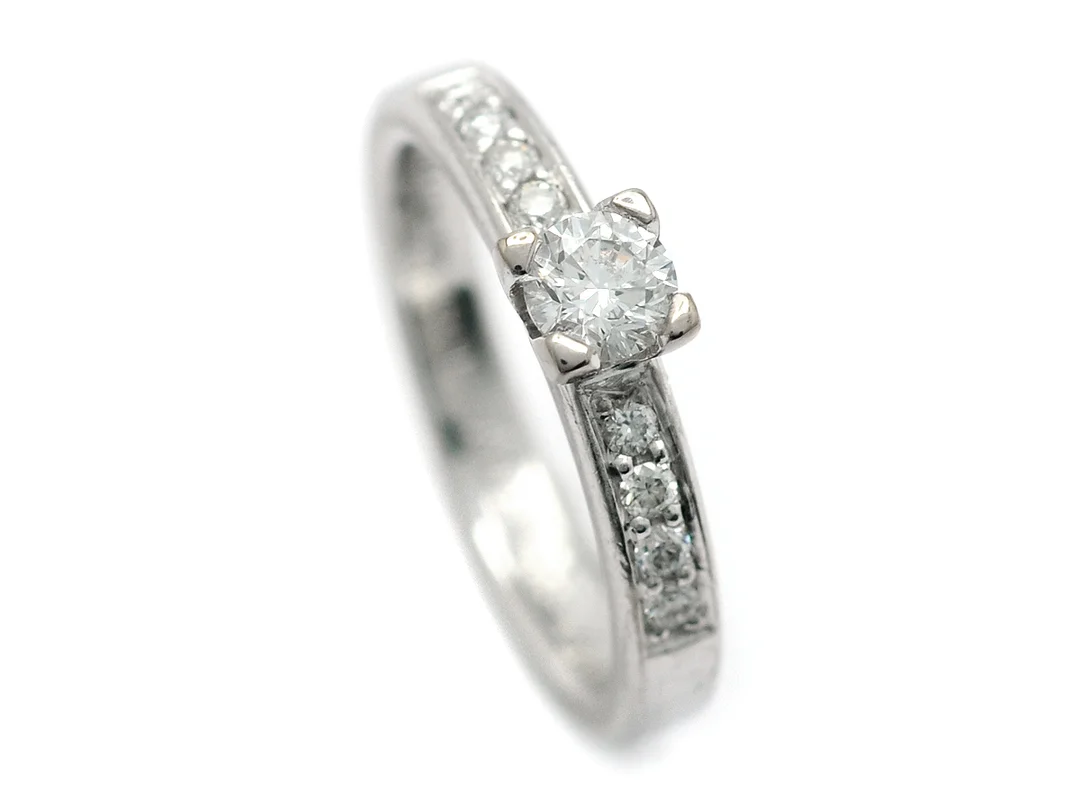 SCHALIN, ring, 18K vitguld, briljantslipad diamant 0,25 ct, 8 briljantslipade diamanter 0,16 ctv, ca W/VS-SI, stl 15,75 mm, vikt 4,5 g, gravyr. — Smycken/Ring — Kaplans