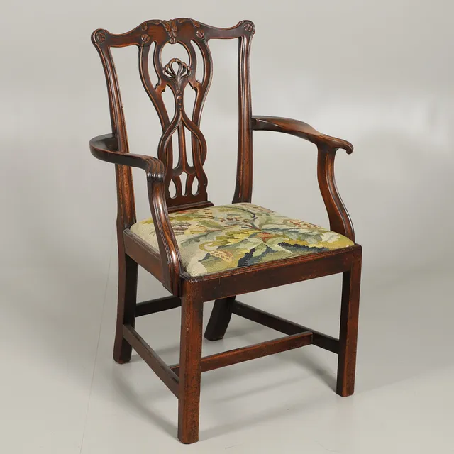A MAHOGANY CHIPPENDALE PATTERN ELBOW CHAIR.