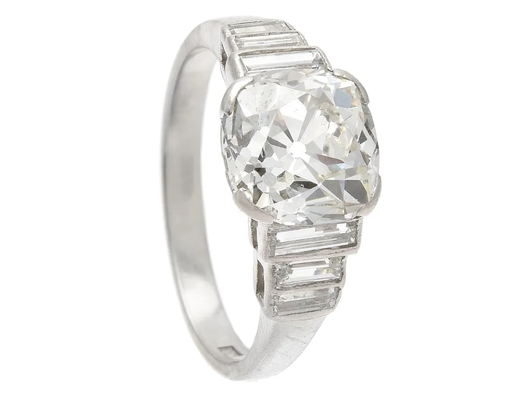 RING, platina, antikslipad diamant ca 3,60 ct, ca TCa(K)/VS2-SI1, 6 baguetteslipade diamanter 0,50 ctv, stl 18+ mm, vikt 6,3 g, liten spricka i fattningen, diamanten har liten skada och små nagg. — Smycken/Ring — Kaplans