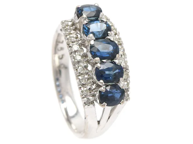 RING, 18K vitguld, 5 ovalslipade blå safirer ca 1,80 ctv, 18 åttkantslipade diamanter ca 0,10 ctv, stl 16,5 mm, vikt 4,9 g, svaga fattningar, safirerna har nagg, en diamant skadad och några med nagg.