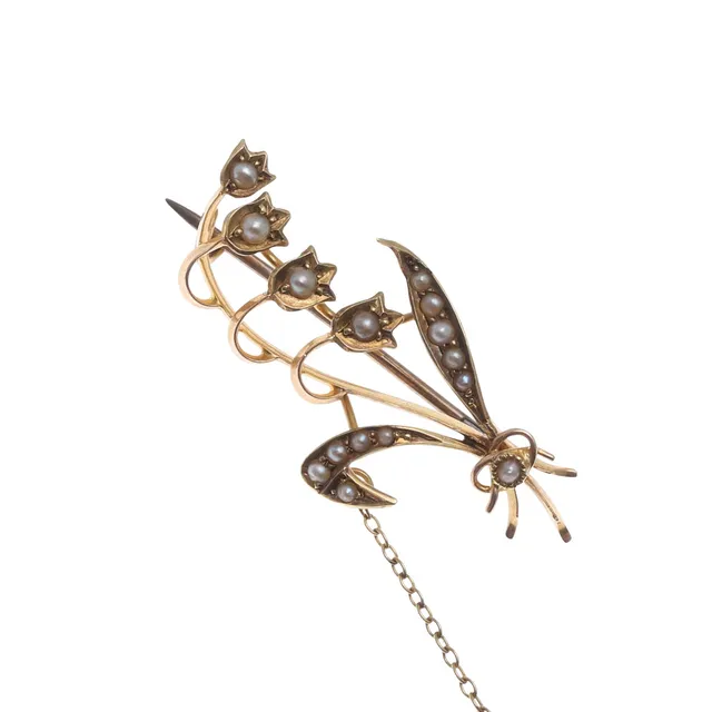 A 15CT GOLD AND PEARL SET LILY OF THE VALLEY BROOCH.