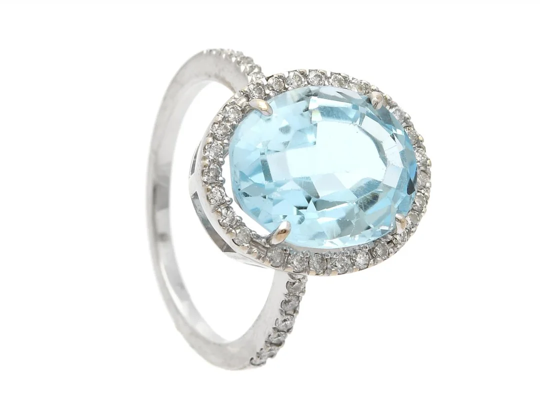 RING, 14K vitguld, ovalslipad topas ca 7,50 ct, briljantslipade diamanter ca 0,40 ctv, ca TW-TCa/VS-P, stl 17,5 mm, vikt 5,7 g, topasen har lätt slitage och rör sig något i fattningen, några diamanter har nagg. — Smycken/Ring — Kaplans