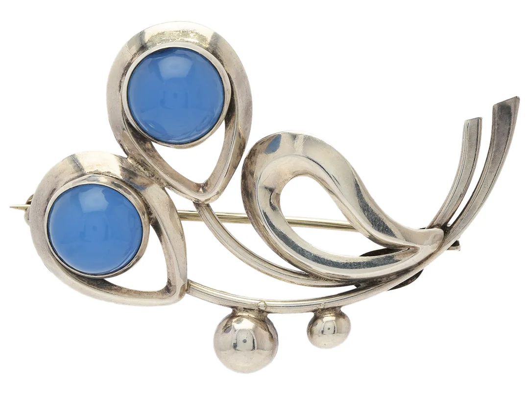 BROSCH, sterlingsilver, 2 blå cabochonslipade stenar, Hermann Siersbol, Danmark, längd 4 cm, vikt 6,1 g, en sten med nagg. — Smycken/Brosch — Kaplans