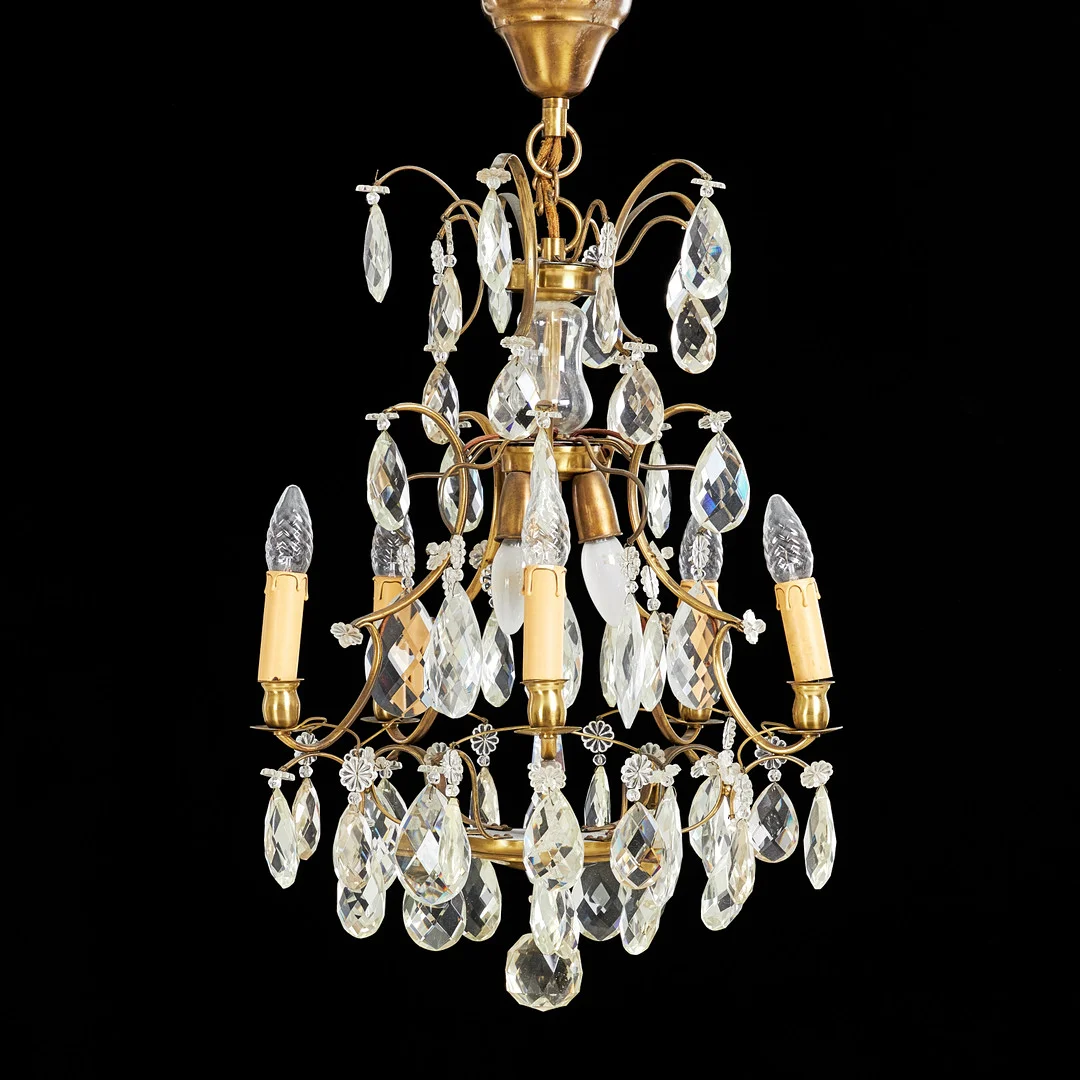 LJUSKRONA, stomme i mässing, 1900-tal, behängd med olikformade prismor. — Chandeliers — Stockholms Auktionsverk Sickla
