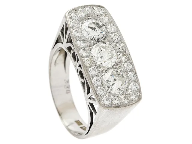 RING, 18K vitguld, 3 briljantslipade diamanter ca 1,65 ctv ca Cr-TCa(J-K)/P1, 24 briljantslipade diamanter ca 0,72 ctv, ca W-Ca/SI-P, Stockholm 1966, stl 17,75 mm, vikt 9,3 g, en liten diamant skadad.