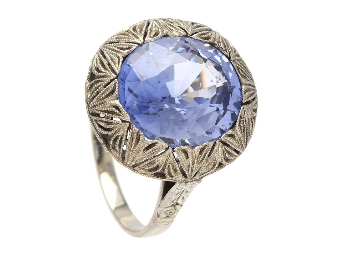 RING, 18K vitguld, ovalslipad syntetisk safir, stl 17,5+ mm, vikt 4,0 g, safiren rör sig i fattningen och har nagg på paviljongen. — Smycken/Ring — Kaplans