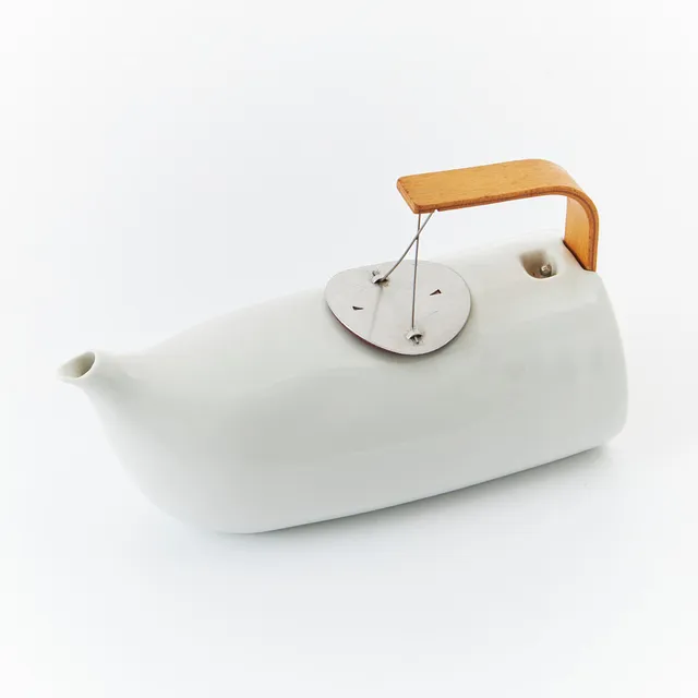CATHERINE LÉVY och SIGOLÈNE PRÈBOIS. Tekanna "Mirza" för Tsé-Tsé. vitglaserat porslin med handtag i bik och lock och sil i aluminium.