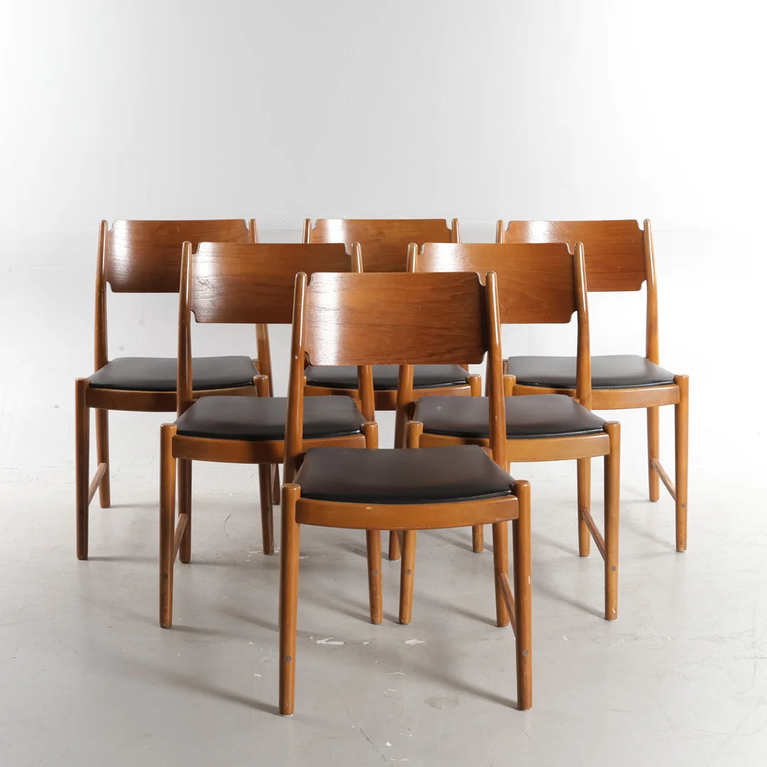 DANSK MØBELDESIGN. Sæt på seks stole med kopstykker af teak, stel af bejdset bøg med synlige samlinger bagtil, sæder betrukket med sort skai. Fremstillet hos SAX, Danmark, 1950-60'erne (6). — Armchairs & Chairs — Woxholt Auktioner