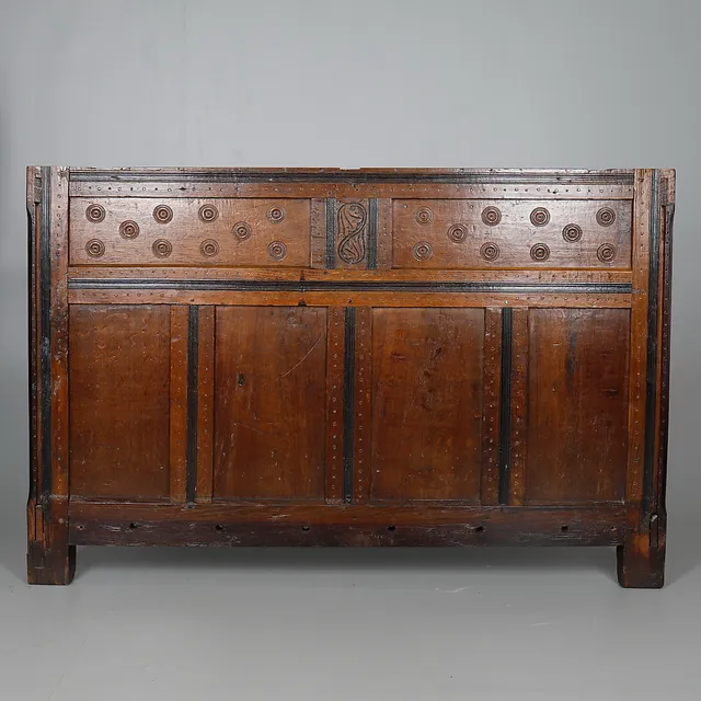 A 17TH CENTURY CARVED OAK BED END.