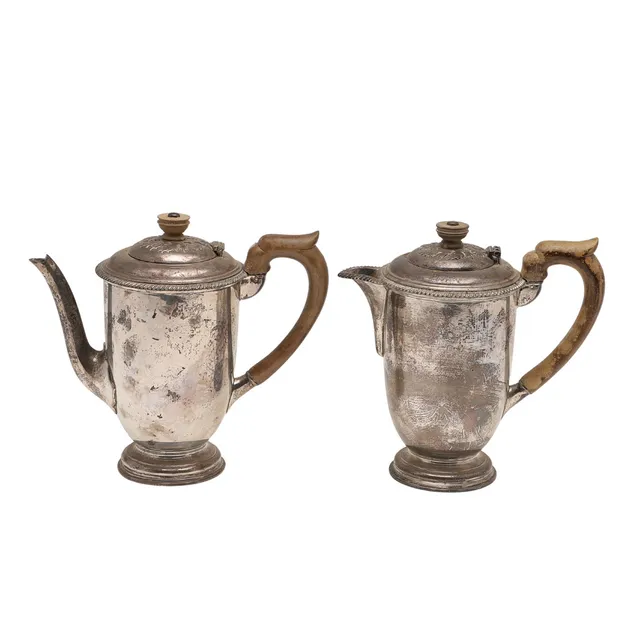 A VERY NEAR PAIR OF 20TH CENTURY SILVER CAFE AU LAIT POTS.
