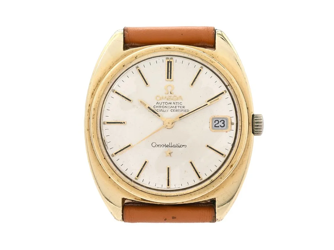 OMEGA, Constellation "C", Chronometer, Cal 564, Serie nr. 31477625, Ref nr. CD 168.017, Boett nr. 168.017 SP (K.B), herrur, 35 mm, guld på stål (skadad), automatisk, plexiglas, datum, skadad urtavla, defekt (akut servicebehov), läderband, ca 1969. — Klockor/Omega — Kaplans