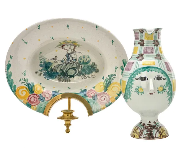 Bjørn Wiinblad: A brass mounted wall lamp and jug of earthenware, decorated with polychrome motifs. (2)