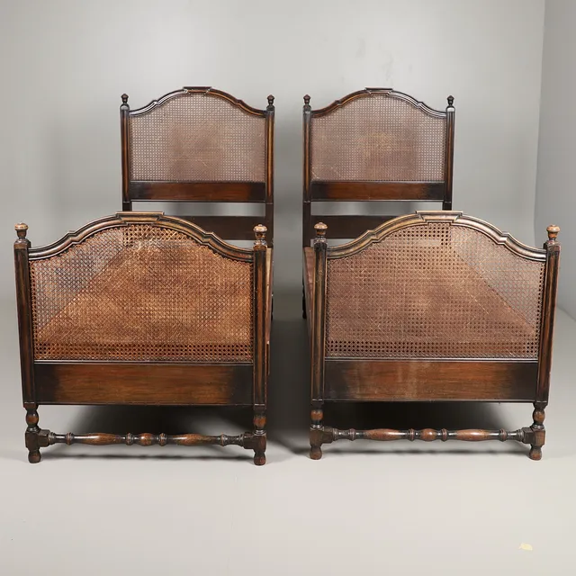 A PAIR OF EARLY 20TH CENTURY HEAL & CO CANE SINGLE BEDS.