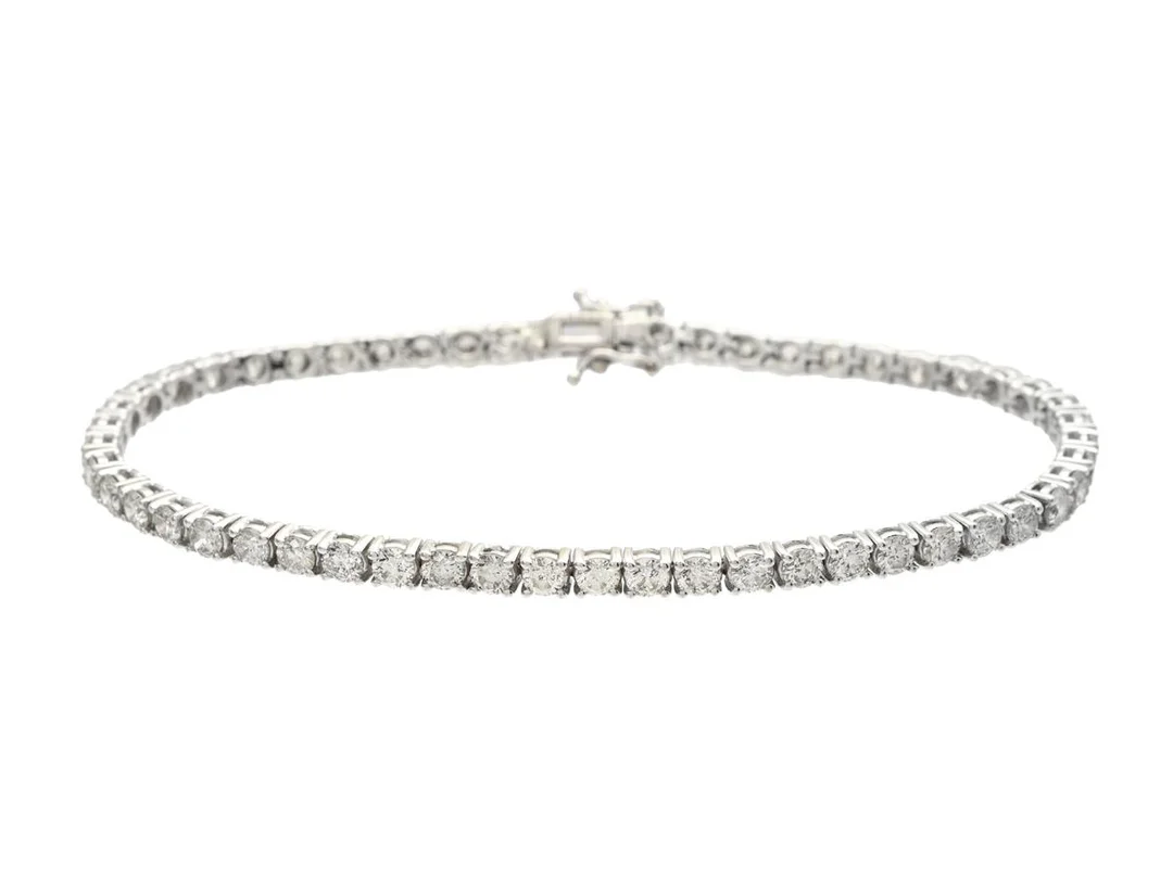 TENNISARMBAND, 18K vitguld, 53 briljantslipade diamanter ca 5,11 ctv, ca TCr-Ca(I-M)/P, någon enstaka diamant ca Light Yellow, längd 17,5 cm, vikt 9,8 g, några diamanter med nagg och ytliga inneslutningar varav någon enstaka bryter igenom ytan. — Smycken/Tennisarmband — Kaplans