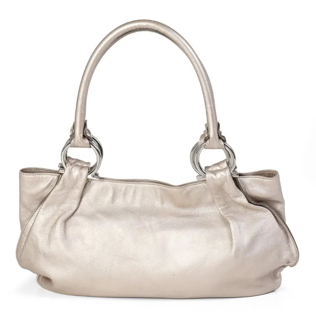A bag of silver coloured leather with silver tone hardware, two handles, one compartment with a magnetic closure, three interior pockets and fabric lining. H. 20 x W. 40 x D. 12 cm.