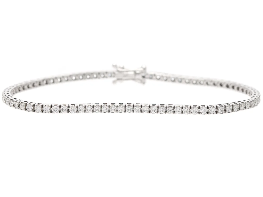 TENNISARMBAND, 18K vitguld, 81 briljantslipade diamanter ca 1,66 ctv, ca TW-TCr/VVS-VS, längd 16,5 cm, vikt 7,7 g. — Smycken/Armband — Kaplans