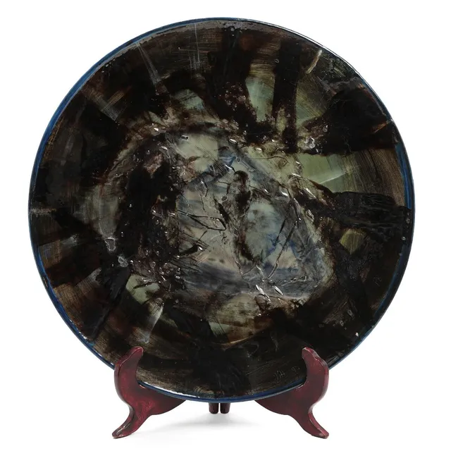 A circular stoneware dish decorated with polychrome glaze, 1997. Signed and dated PB, ISH 97 (scratched in the glaze) and signed and dated underneath Peter Brandes, 97. Manufactured and marked by Tommerup Keramisk Værksted. Unique. Diam. 51 cm.
