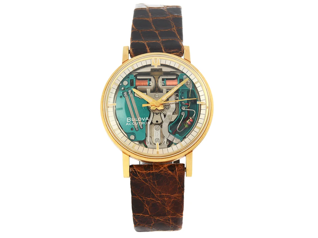 BULOVA, Accutron, "Spaceview", Cal 214 H (M8), Serie nr. M5, Boett nr. 1-484465 / 340-1, herrur, 35,5 mm, 18K guld, stämgaffel, plexiglas, läderband, originalspänne i doublé, ca 1966, träbox. — Klockor/Bulova — Kaplans