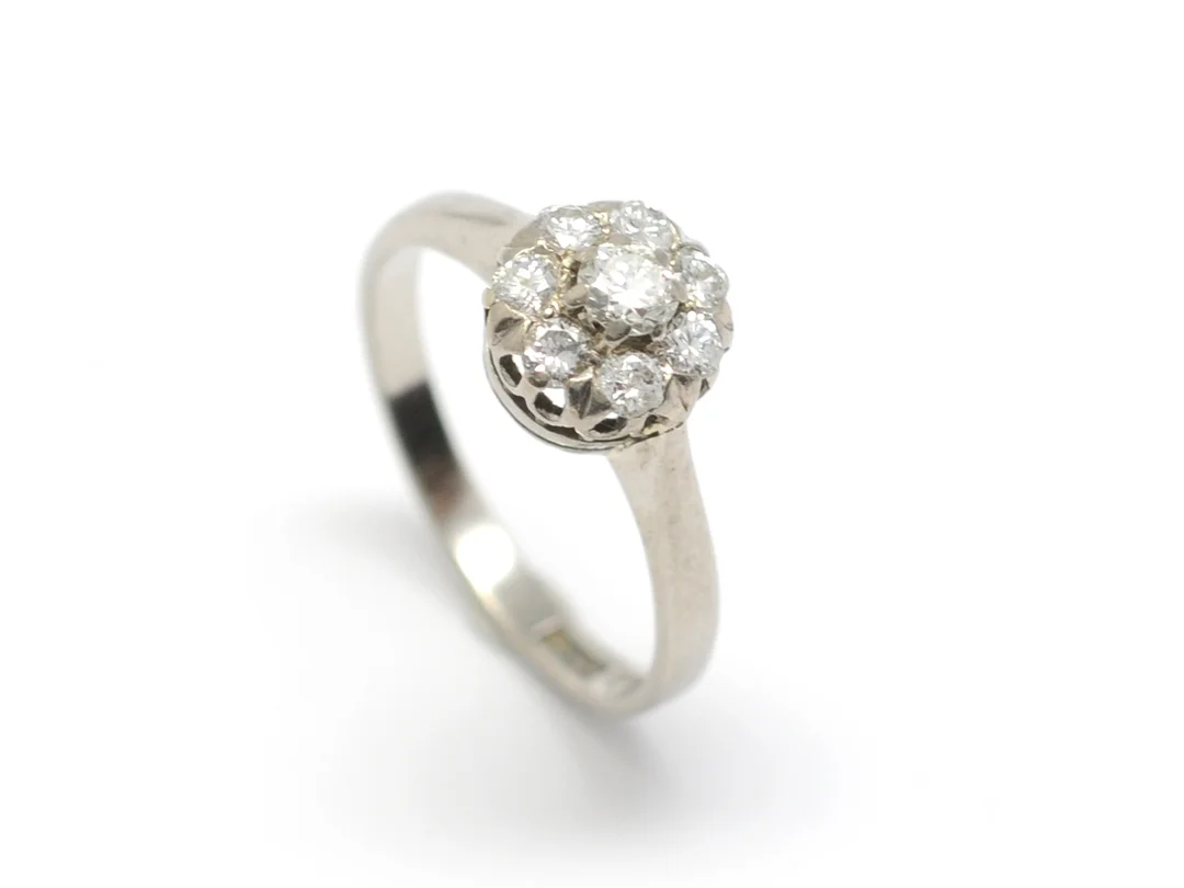 RING, 18K vitguld, 8 briljanter ca 0,54 ctv, ca W-TCA/VS-SI, Guldvaruhuset i Köping, Köping 1961, stl 17+ mm, vikt 3,5 g, två av de mindre diamanterna är skadade. — Smycken/Ring — Kaplans