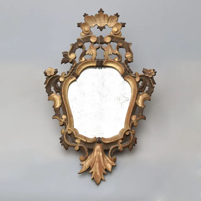Elizabethan ornamental mirror in carved, gilt and patinated wood, second half of the 19th Century.