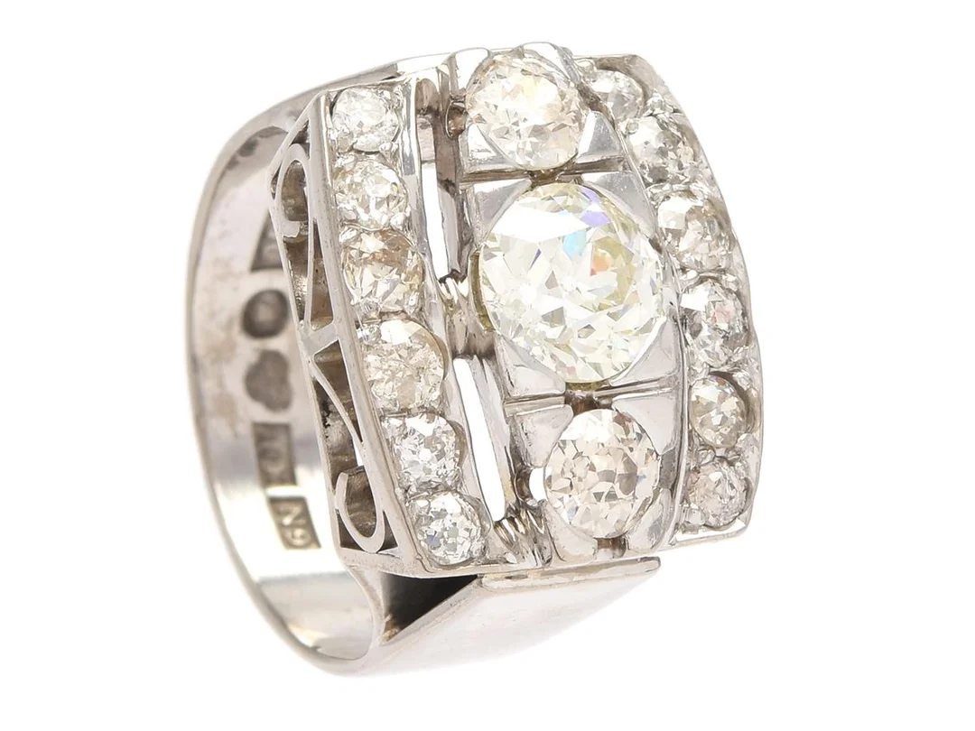 RING, 18K vitguld, gammalslipad diamant ca 1,30 ct, ca LY/P1, gammalslipade diamanter ca 1,20 ctv, ca TW-TCa/SI-P, Evert Gustafsson, Stockholm 1963, stl 17,75 mm, vikt 11,8 g, några diamanter med nagg och skador samt inneslutningar som når ytan. — Smycken/Ring — Kaplans