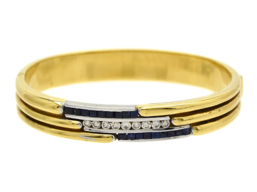 ARMRING, 18K guld, delvis rodierat, 9 briljanter ca 0,50 ctv, ca TCr/VS, 18 safirer ca 0,75 ctv, inre omkrets 16,5 cm, öppningsbart, vikt 46,2 g.G, — Smycken/Armring — Kaplans