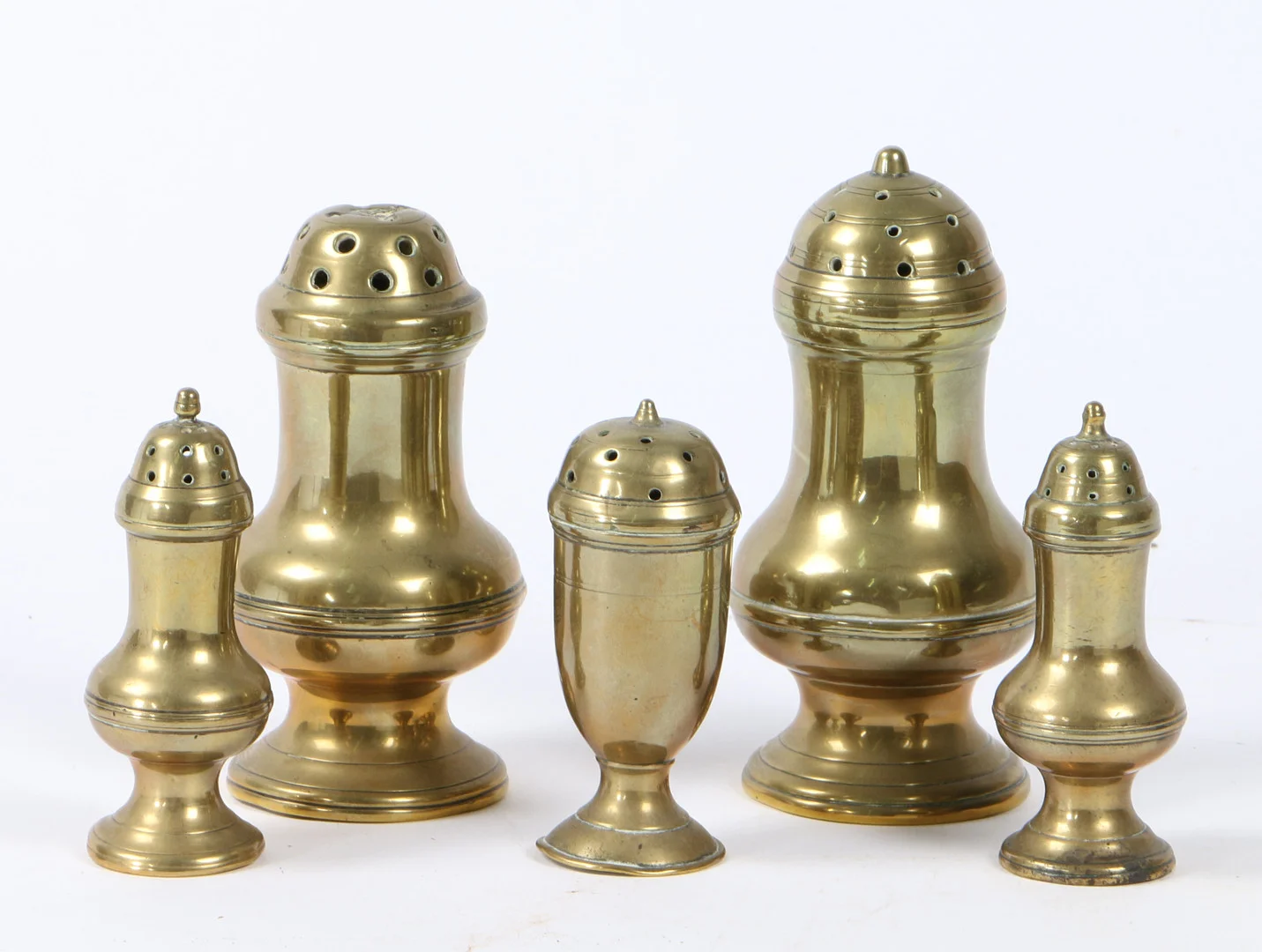 A GROUP OF FIVE GEORGE III BRASS CASTERS OR PEPPERETTES, CIRCA 1770-1800. — Pewter, Brass & Copper — Bishop & Miller