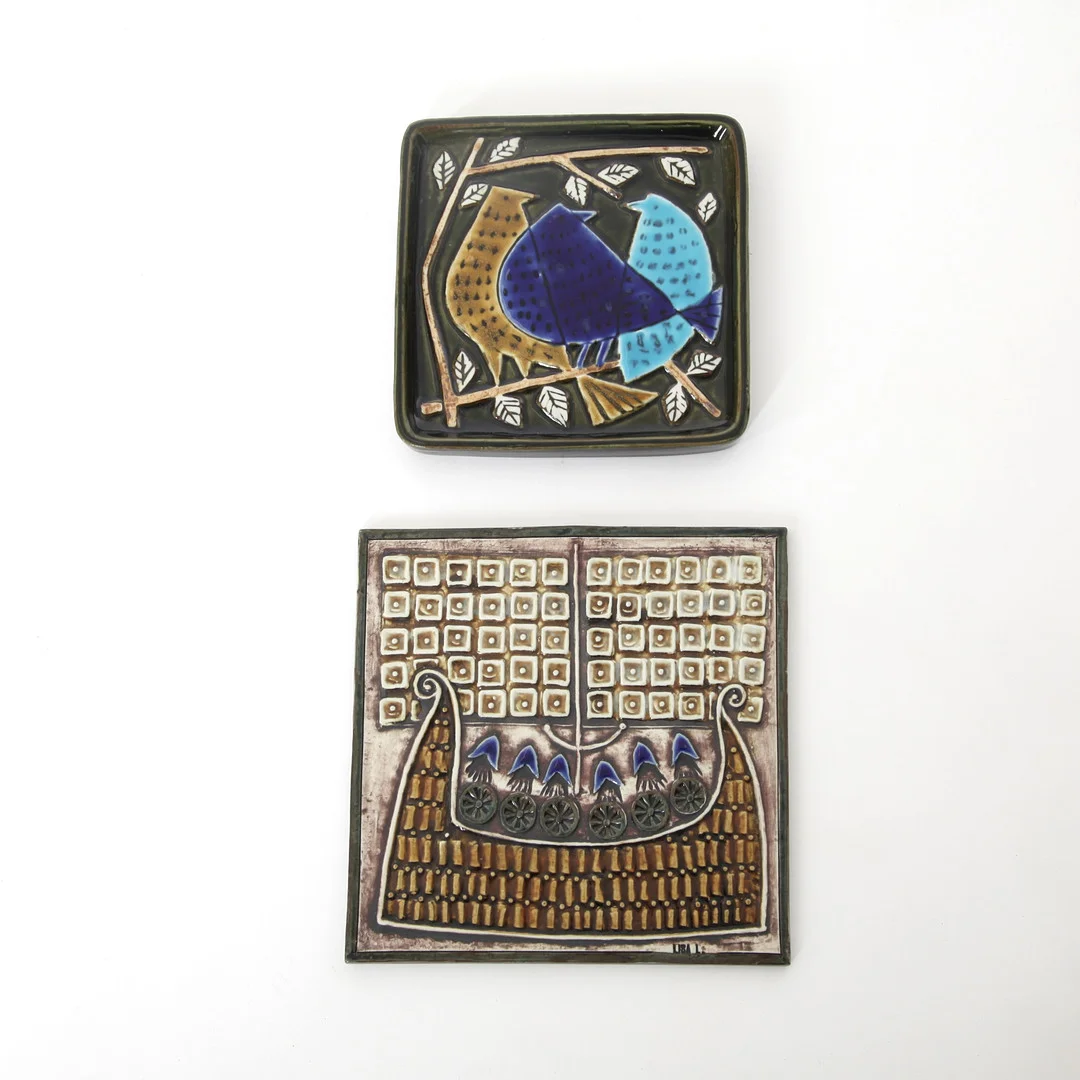 LISA LARSON. 1931-2024. Väggplaketter, 2 st, "Harlekin" samt "Skepp" ur serien Unik, Gustavsberg, 1900-talets andra hälft. — European — Auktionsverket Engelholm