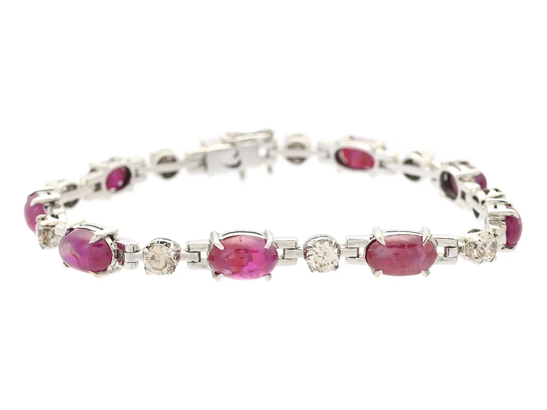 ARMBAND, 14K vitguld, cabochonslipade rubiner, briljantslipade diamanter ca 1,41 ctv, ca TCa-Ca(K-N)/VS-P, längd 16,5 cm, vikt 13,6 g, stenar med nagg och skador. — Smycken/Armband — Kaplans