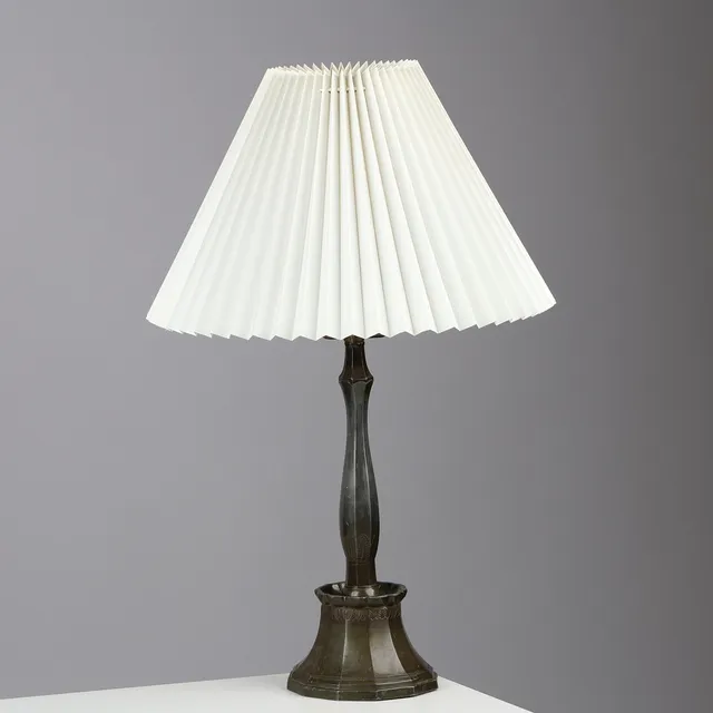JUST ANDERSEN (1884-1943). Bordlampe af diskometal med kantet fodstykke støbt med stiliserede blade, Just Andersen, Danmark, formgivet 1926-1929.
