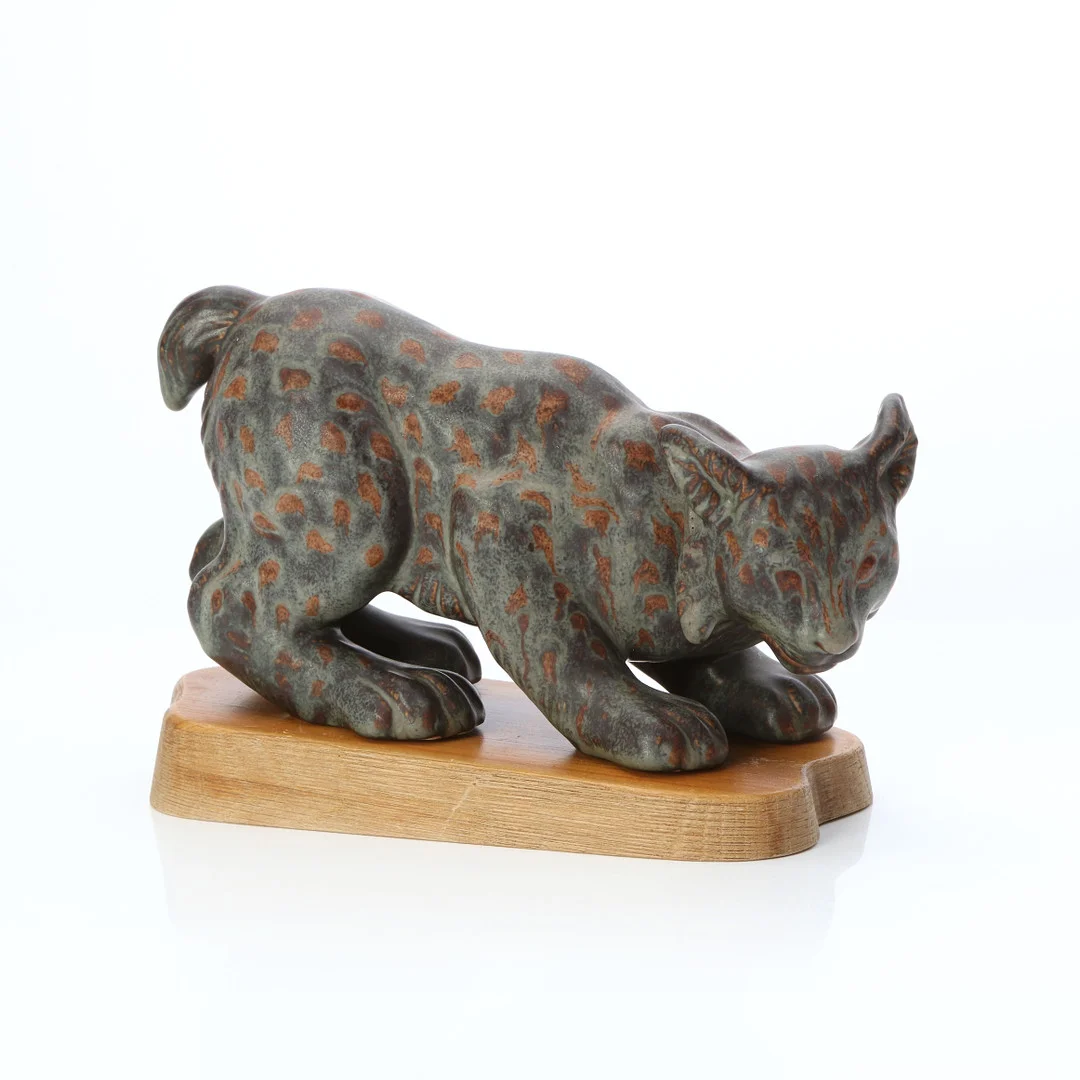 GUNNAR NYLUND. KERAMIKSKULPTUR. Stengods på träsockel. Lodjur. Rörstrand, märkt undertill. — European — Skånes Auktionsverk