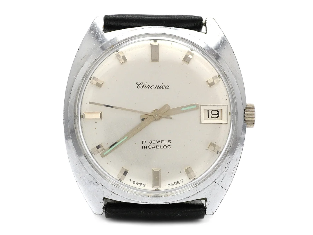 CHRONICA, herrur, 34 mm, Boett nr. 7017, vitmetall, manuell, plexiglas, datum, skadad urtavla, skadad boett, läderband, ca 1970. — Klockor/Övriga klockor — Kaplans