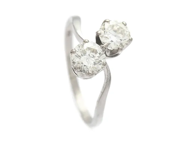 SYSKONRING, platina, gammalslipad diamant ca 0,50 ct, ca W(H)/VS, briljantslipad diamant ca 0,70 ct, ca TCr(I)/SI, stl 18 mm, vikt 3,4 g, gammalslipade diamanten har litet nagg på rondist, briljantslipade diamanten har skada i form av nagg och spricka vid rondist.