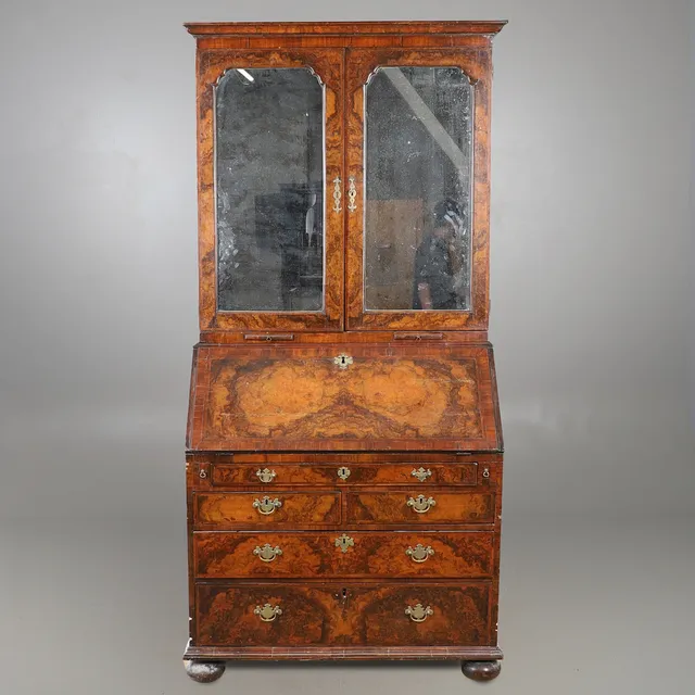 A GEORGE I BURR WALNUT & FEATHERBANDED BUREAU BOOKCASE.