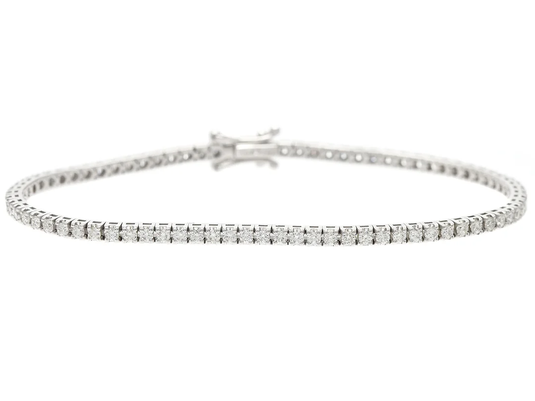 TENNISARMBAND, 18K vitguld, 81 briljantslipade diamanter ca 1,66 ctv, ca TW-TCr/VVS-VS, längd 16,5 cm, vikt 7,4 g. — Smycken/Armband — Kaplans