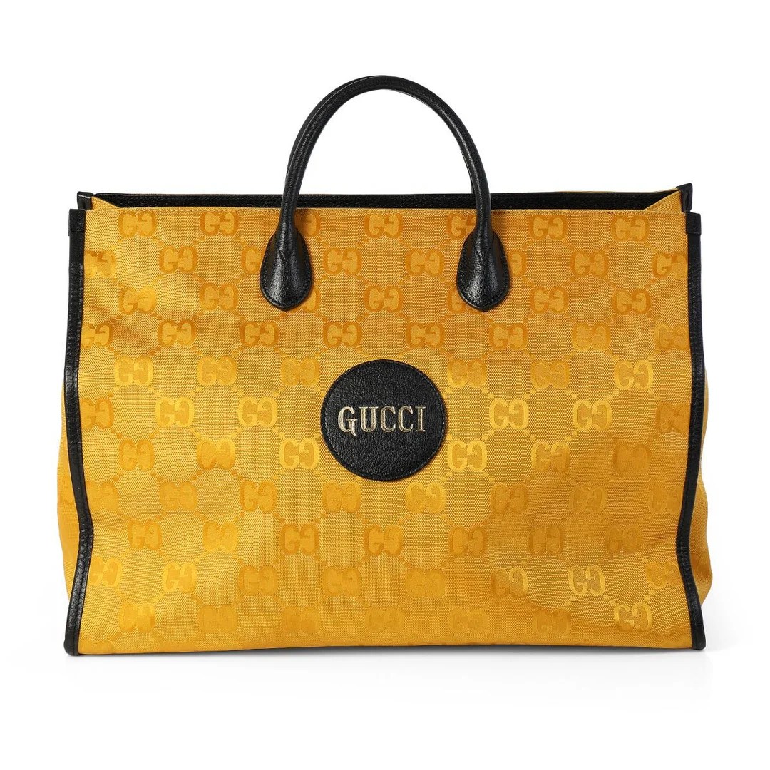 An “Off The Grid” tote bag of yellow monogram canvas with black leather trimmings, gold tone hardware, two handles, detachable and adjustable shoulder strap, one compartment with a clasp closure and two interior zipped pockets. H. 32 x W. 42 x D. 20 cm. — Designer Handbags & Fashion/Designer Handbags — Bruun Rasmussen