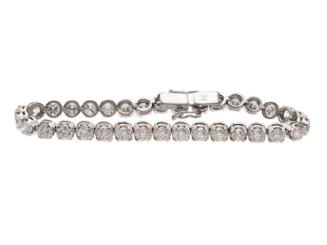 TENNISARMBAND, 18K vitguld, 34 briljantslipade diamanter ca 9,25 ctv, ca Cr-TCa/VS-P, längd 17 cm, vikt 15,2 g, en diamant med är skadad. — Smycken/Armband — Kaplans