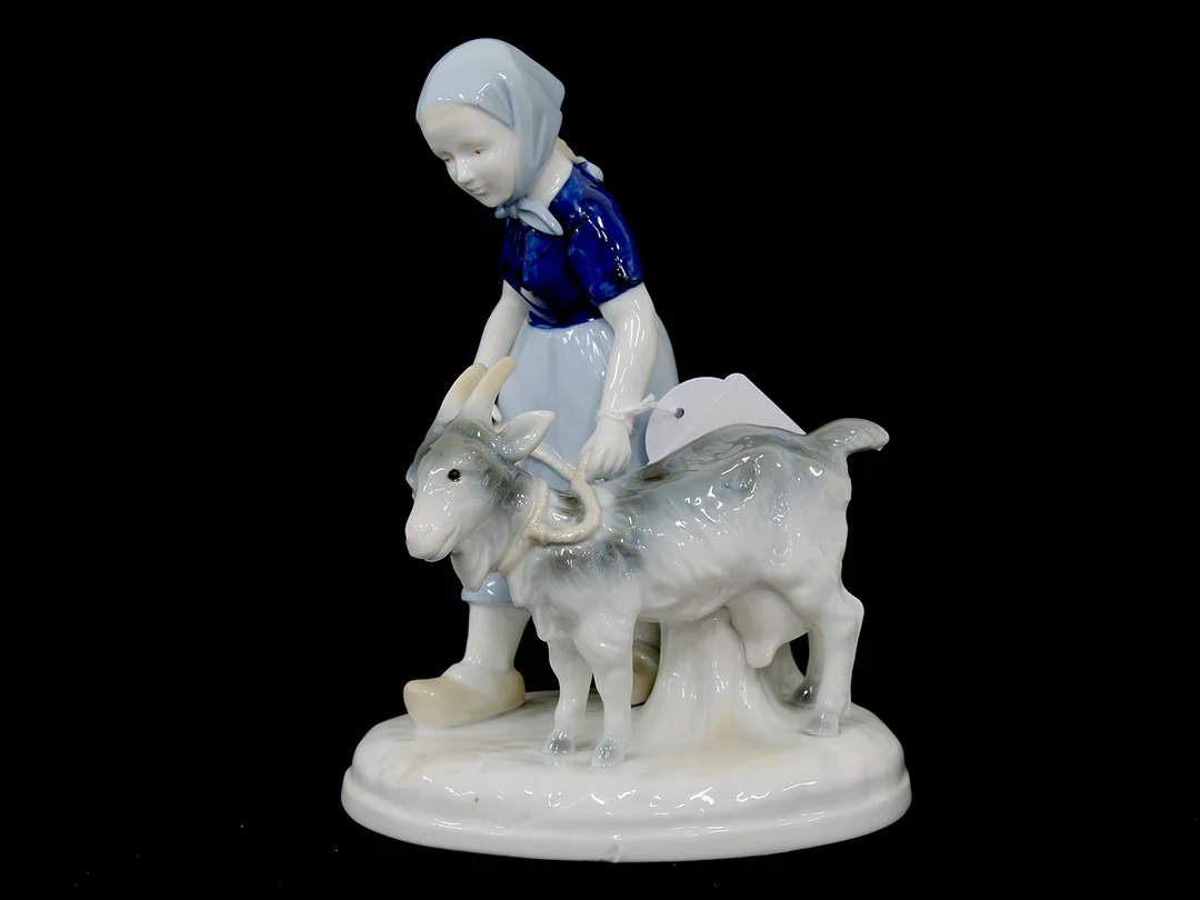 Figurin, flicka med get, design Carl Scheidig, höjd 19,5cm, bredd 14,5cm, små tillverkningsdefekter — Porslin/Övrigt — Kaplans