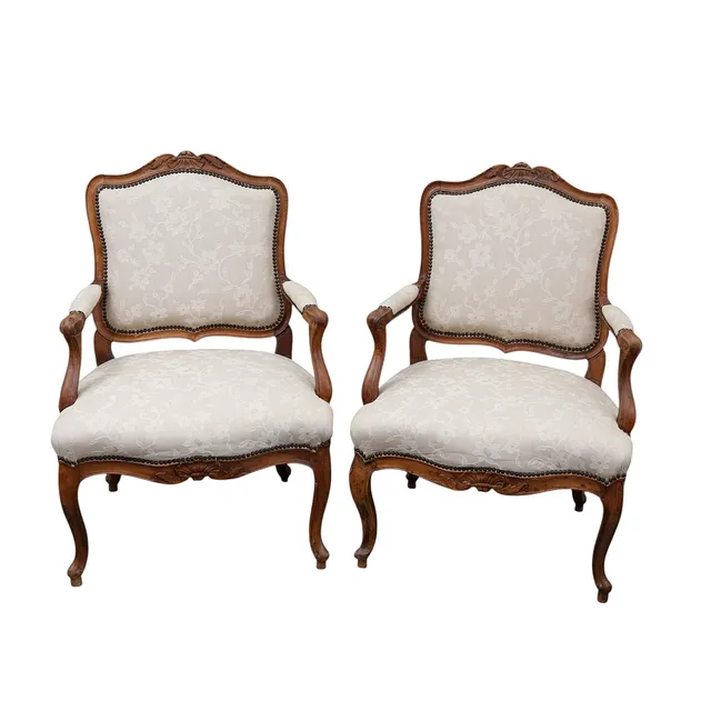 Pair of Louis XV “à la reine” French armchairs in carved walnut, 18th century.