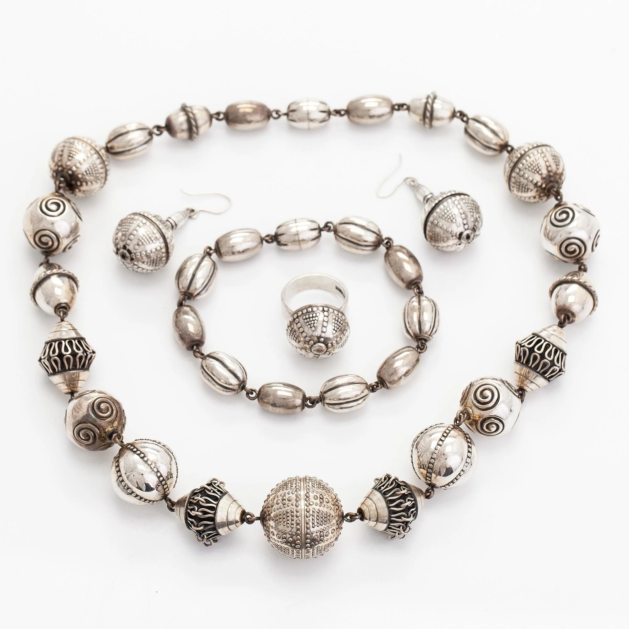 Kalevala Koru, halsband, armband, ring och örhängen, "Skatten från Halikko", sterlingsilver. Helsingfors 1994. — Smycken/Collier & Hängsmycken — Bukowskis