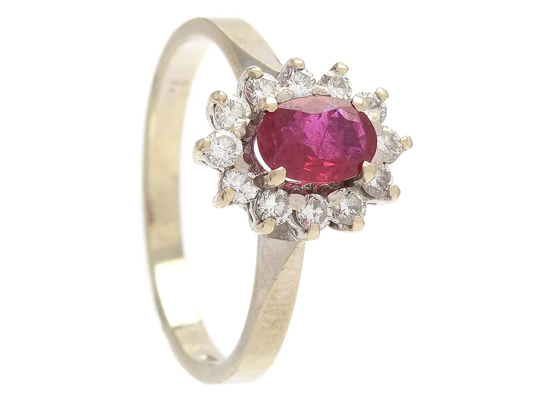 CARMOSÉRING, 18K vitguld, ovalslipad rubin 0,46 ctv enligt gravyr, 12 briljantslipade diamanter ca 0,24 ctv, ca W-CR/VS-SI, stl 15,75 mm, vikt 2,5 g — Smycken/Carmoséring — Kaplans