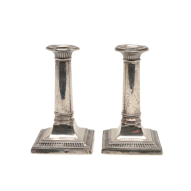 A GEORGE V PAIR OF SILVER CANDLESTICKS.